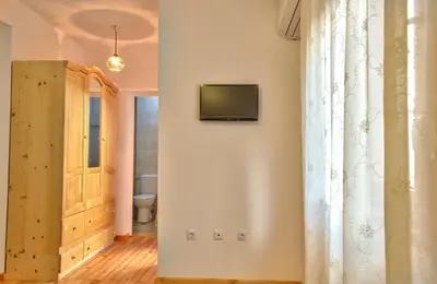 a bathroom with a television on a white wall at Guest House JoJi in Sapareva Banya