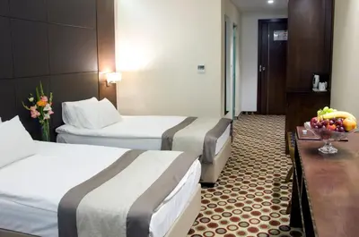 a hotel room with two beds and a bowl of fruit at Central Hotel Sofia in Sofia