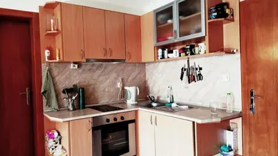 a kitchen with wooden cabinets and a counter top at Lara's cosy apartment 200 m from lift in Bansko