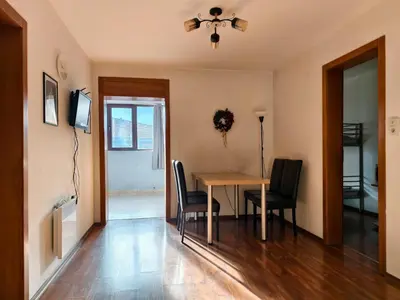 a dining room with a table and chairs and a ceiling fan at Lara's cosy apartment 200 m from lift in Bansko
