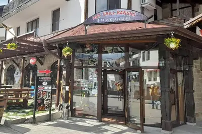 a building with a sign on top of it at Lara's cosy apartment 200 m from lift in Bansko