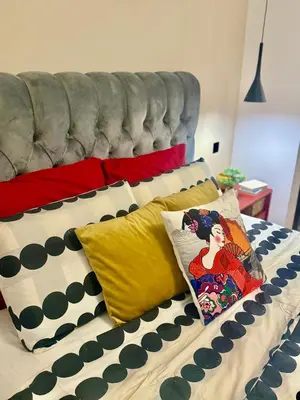 a bed with colorful pillows on it with a couch at Luxury apartment in the heart of Sofia in Sofia