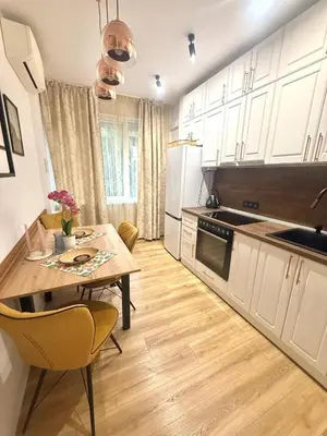 a kitchen with a wooden table and a dining room at Luxury apartment in the heart of Sofia in Sofia