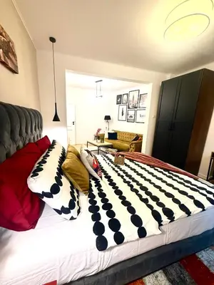 a bed with black and white pillows on it at Luxury apartment in the heart of Sofia in Sofia