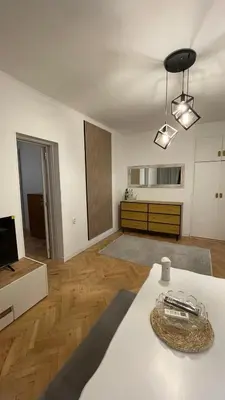 a living room with a table and a television at Кокетно Кътче in Sofia