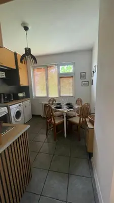 a kitchen with a table and chairs in a kitchen at Кокетно Кътче in Sofia