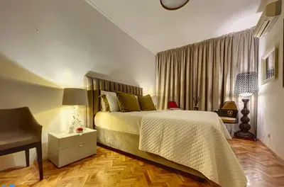 a bedroom with a bed and a table and a desk at Superbe last floor next Presidency in Sofia