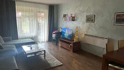 a living room with a couch and a flat screen tv at Eleonor Mountain Apartment 2 in Bansko