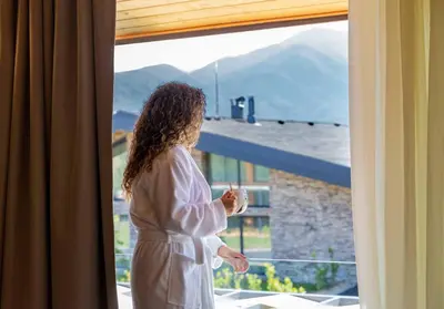 a woman is looking out of a window at Hypnotic Thermal Villas with private SPA in Banya