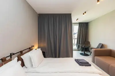 a hotel room with a bed and a couch at Eleve Residences - Obsidian Studios in Sofia