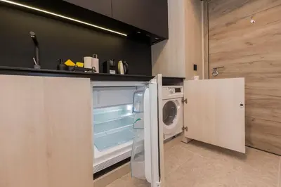 a kitchen with a refrigerator and a washing machine at Eleve Residences - Obsidian Studios in Sofia