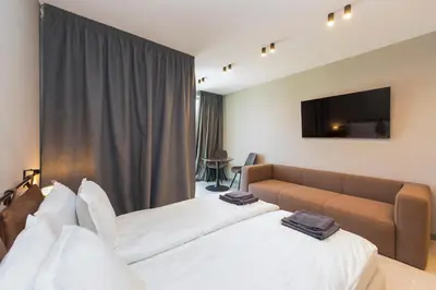 a hotel room with two beds and a couch at Eleve Residences - Obsidian Studios in Sofia