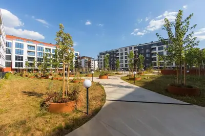 a walkway with trees and buildings in the background at Eleve Residences - Obsidian Studios in Sofia