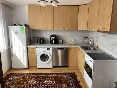 a kitchen with a refrigerator and a washing machine at Къща за гости Хриси in Mala Tsŭrkva