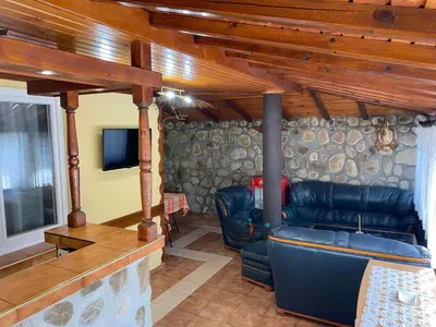 a living room with a couch and a tv at Къща за гости Хриси in Mala Tsŭrkva