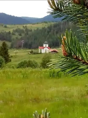 a red and white house in a green field at Къща за гости Хриси in Mala Tsŭrkva