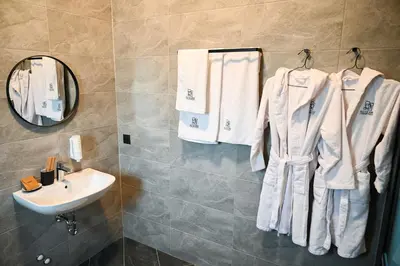 a bathroom with a sink and towels hanging on a wall at Villa Alveare in Banya