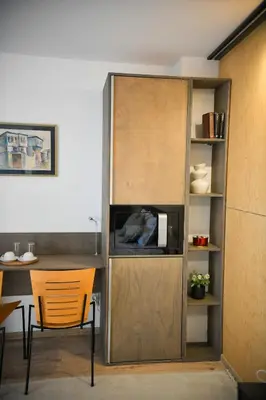 a room with a cabinet with a tv and a table at Villa Alveare in Banya
