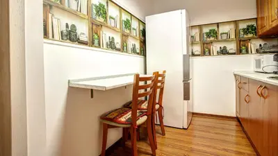 a kitchen with a table and a chair and a refrigerator at River Apartment in Sofia