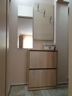 a bathroom with a mirror and a wooden cabinet at Уютнен апартамент Лагера in Sofia