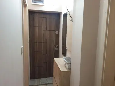 a bathroom with a wooden door and a sink at Уютнен апартамент Лагера in Sofia