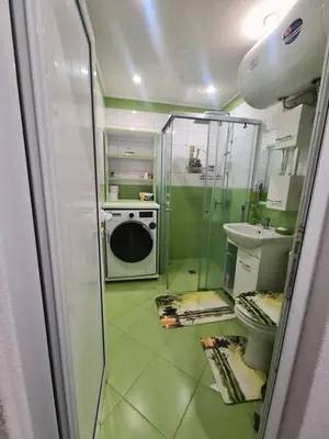 a bathroom with a shower and a washing machine at Cosmopolitan in Devin
