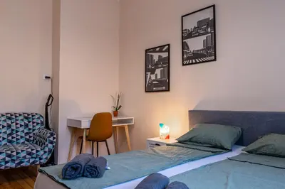 a bedroom with two beds and a desk and a chair at Teo's Cozy Top Central Apartment in Sofia