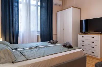 a bedroom with a bed with a television and a dresser at Teo's Cozy Top Central Apartment in Sofia