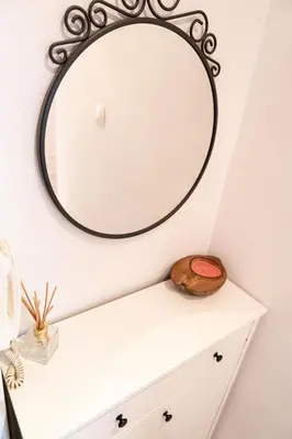 a mirror on a wall above a white dresser at Teo's Cozy Top Central Apartment in Sofia