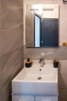 a bathroom with a white sink and a mirror at Skyline Studio in Sofia
