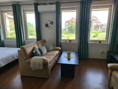 a living room with a couch and a table at Spacious Studio - Bansko Royal Towers in Bansko