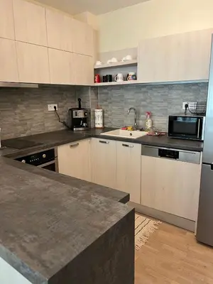 a kitchen with white cabinets and a counter top at Апартамент в сърцето на ПЛОВДИВ in Plovdiv