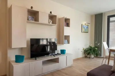 a living room with a flat screen tv on a cabinet at Апартамент в сърцето на ПЛОВДИВ in Plovdiv