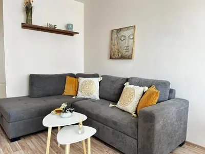 a living room with a gray couch and two tables at Rea Flora - Cozy Stay With Free Parking in Sofia