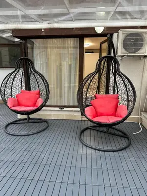 two chairs with red pillows sitting on a boat at Apartment Garden - two large terraces with hanging chairs and sunset view in Sofia