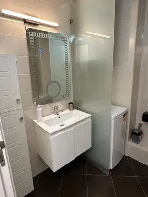 a white bathroom with a sink and a mirror at Apartment Garden - two large terraces with hanging chairs and sunset view in Sofia