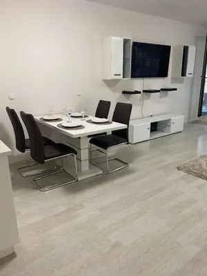 a dining room table with black chairs and a tv at Apartment Garden - two large terraces with hanging chairs and sunset view in Sofia