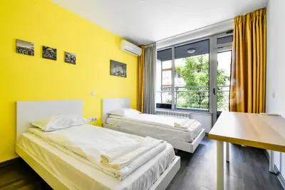 two beds in a room with a yellow wall at Joy Apartment - Stylish 2BD in Oborishte by Flat Mаnager in Sofia