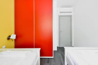 a bedroom with a red wall and a white bed at Joy Apartment - Stylish 2BD in Oborishte by Flat Mаnager in Sofia