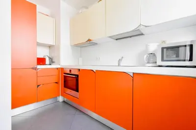 an orange kitchen with white cabinets and a microwave at Joy Apartment - Stylish 2BD in Oborishte by Flat Mаnager in Sofia