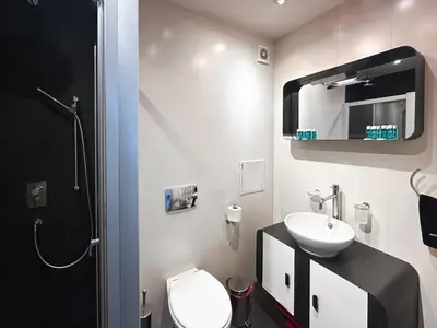 a bathroom with a sink and a toilet and a mirror at Joy Apartment - Stylish 2BD in Oborishte by Flat Mаnager in Sofia