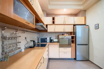 a kitchen with white cabinets and a stainless steel refrigerator at Spacious and Central Retreat in Sofia