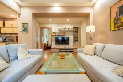 a living room with two couches and a glass table at Spacious and Central Retreat in Sofia