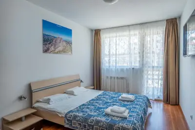 a bedroom with a bed with two towels on it at Belvedere Bansko - Cozy 1BR - Ski in Winter, Swim in Summer! by Flat Mаnаger in Bansko