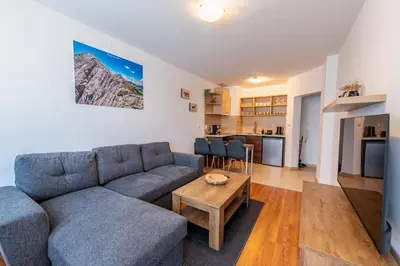 a living room with a couch and a table at Belvedere Bansko - Cozy 1BR - Ski in Winter, Swim in Summer! by Flat Mаnаger in Bansko