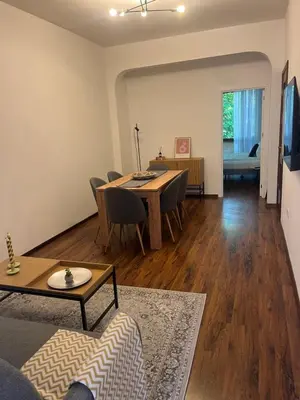 a living room with a table and chairs and a couch at Dunav 11 in Sofia
