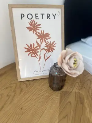 a flower in a vase next to a picture at Dunav 11 in Sofia