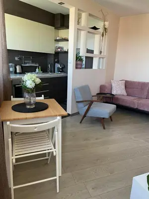 a kitchen and living room with a vase of flowers on a table at Premium High Rise, Gorgeous City Views in Plovdiv