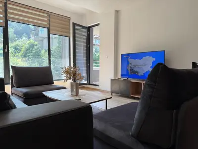 a living room with a couch and a tv at Nikol5 Deluxe in Velingrad