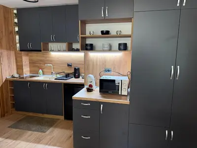 a kitchen with black cabinets and a microwave on a counter at Nikol5 Deluxe in Velingrad